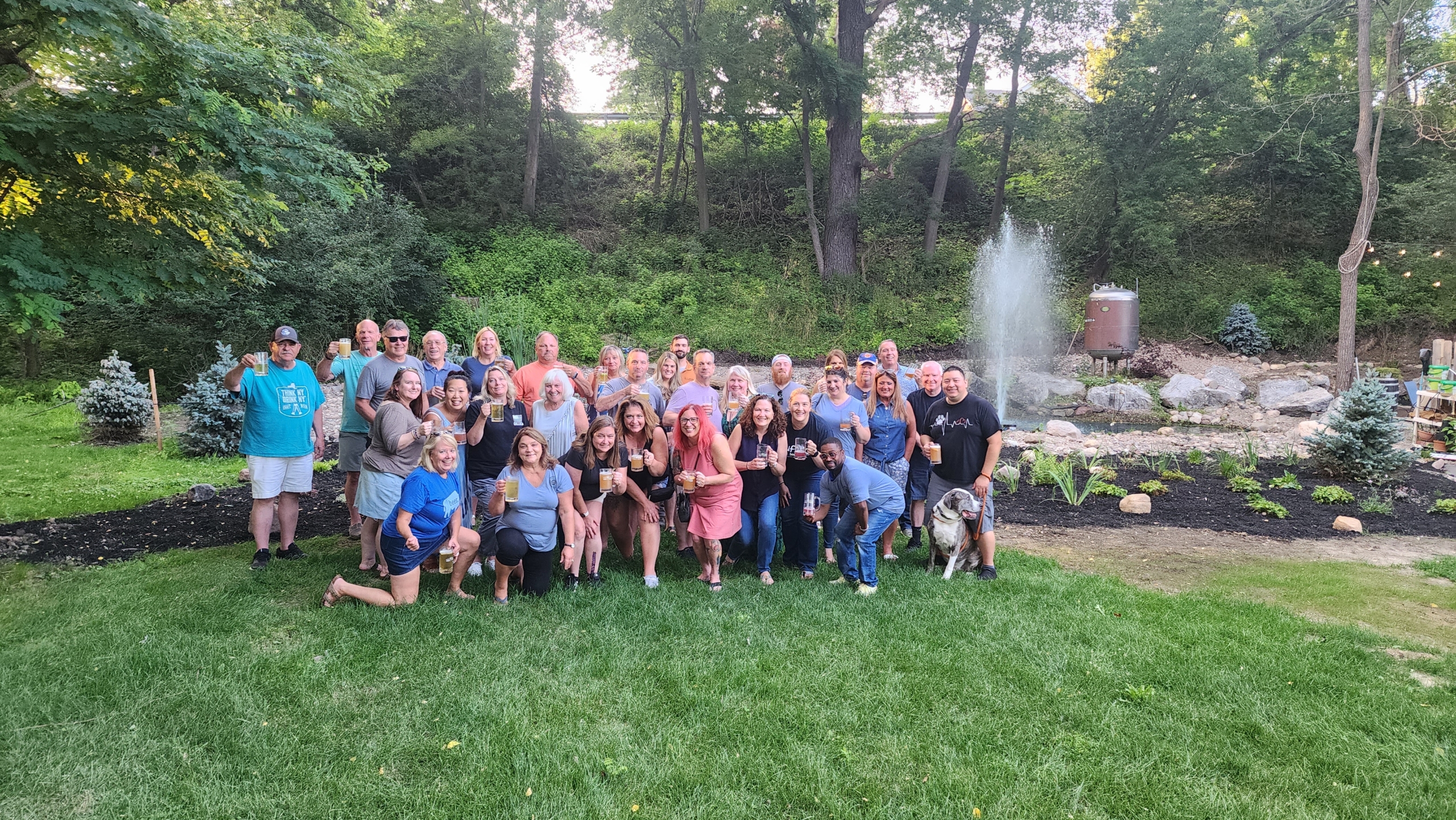 Members of Rusty Nickel's Mug Club pose for a photo in front of the fountain in the beer garden. They proudly hoist their mugs in cheers