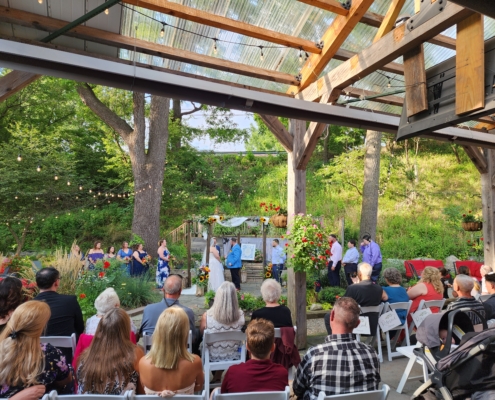 guests are seated for a wedding ceremony in the garden.