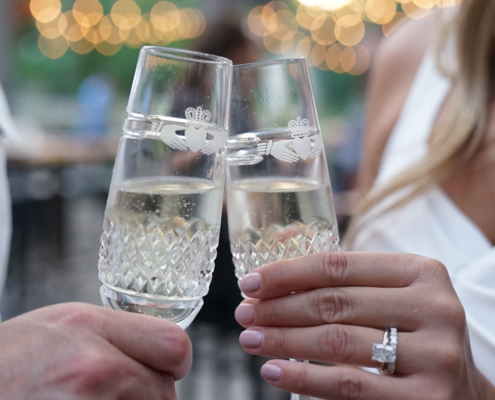 two hands hold champagne flutes