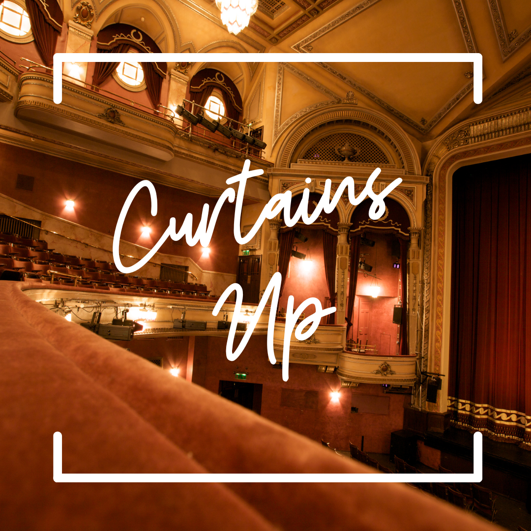 An empty historic theater shown from the balcony. Red velvet seats and curtains fill the space. Text reads "Curtain's Up"