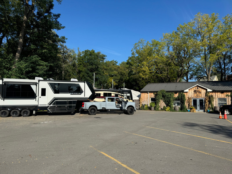 A pick-up truck backs in their fifth wheel camper trailer