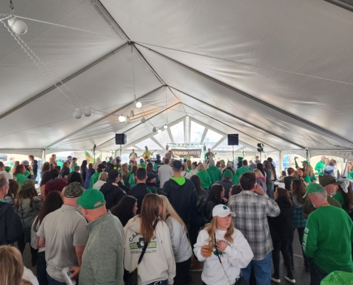 Crowd celebrating under a large tent.