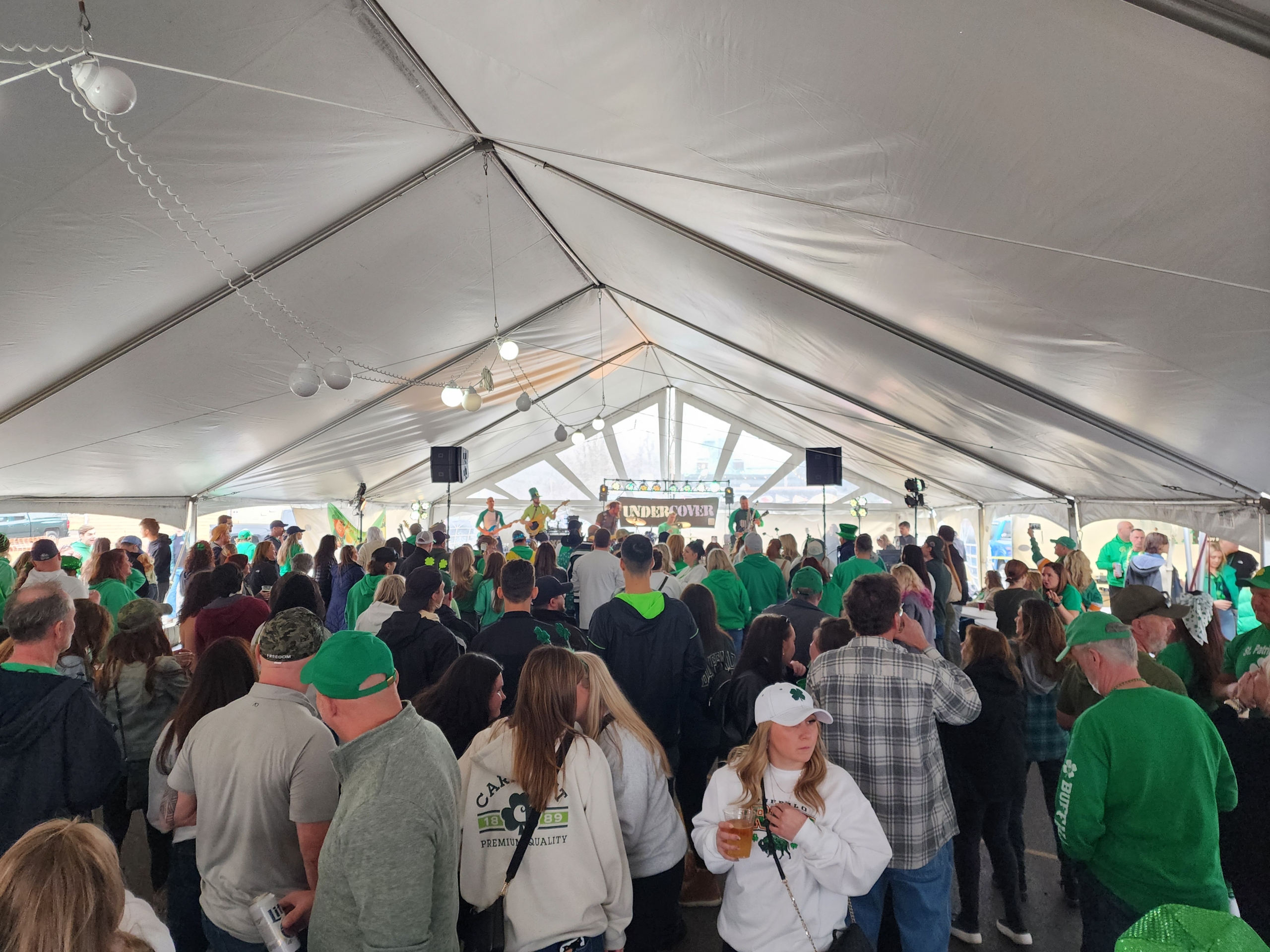 Crowd celebrating under a large tent.