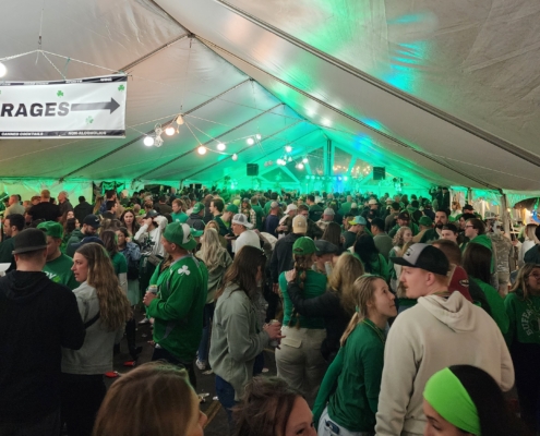 Crowd celebrating under a tent.