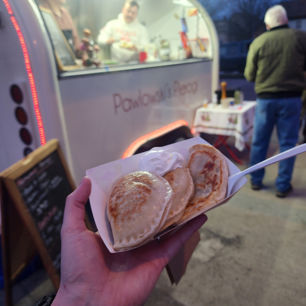 Hand holding three pierogis