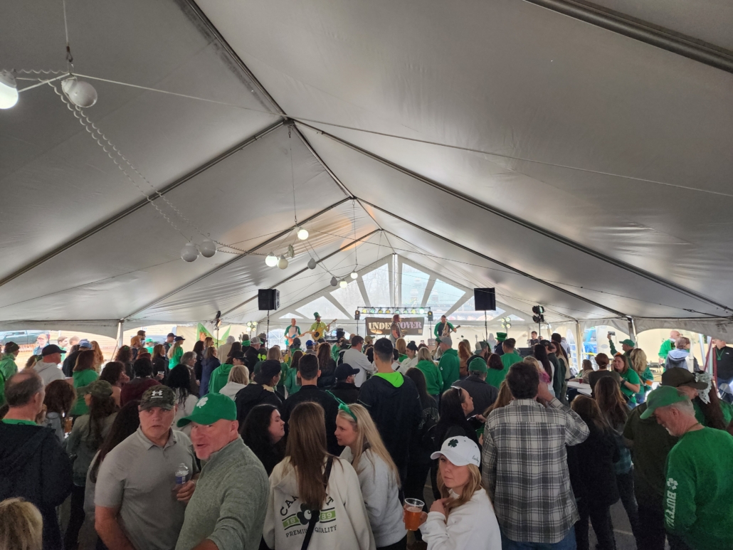Crowd celebrating under a large tent.
